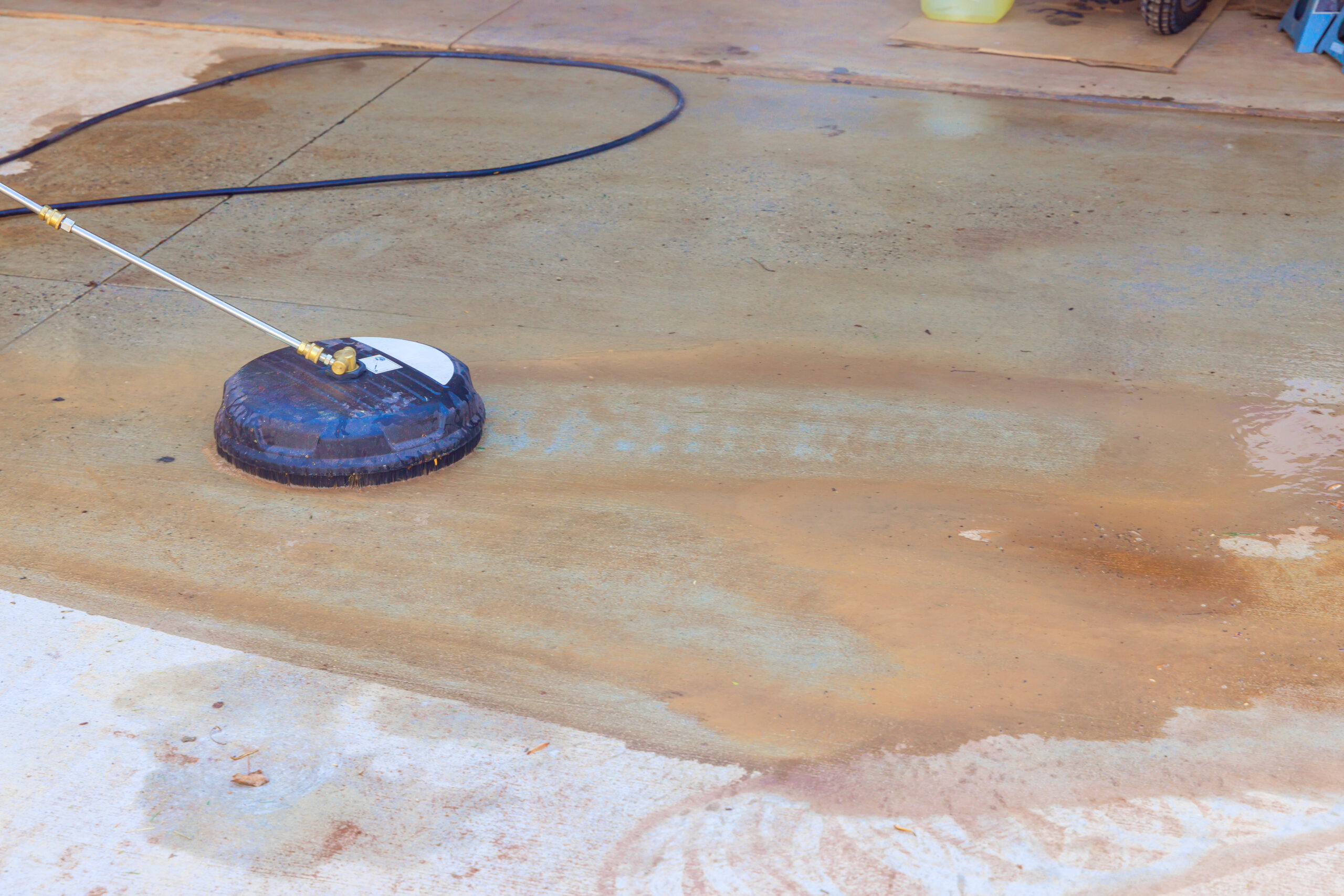Pressure Washing Dirty Driveway – Peoria, IL - River City Pressure Washing Surface cleaner pressure washing a dirty concrete driveway in Peoria, Illinois during professional cleaning by River City Pressure Washing.