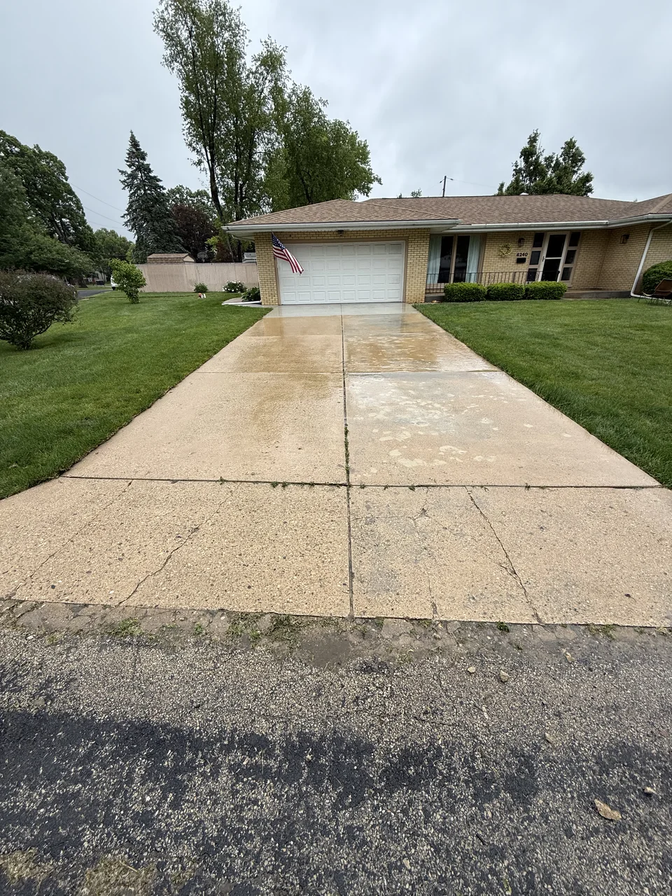 Concrete driveway leading to a garage after cleaning by River City Pressure Washing