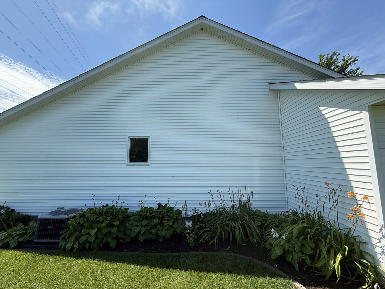White siding on the side of a home after cleaning by River City Pressure Washing
